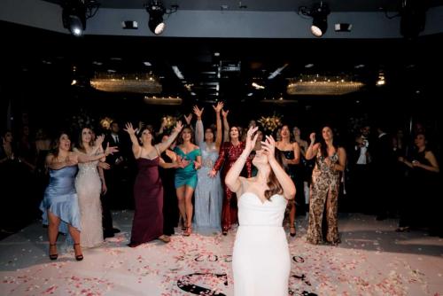 bride-throwing-bouquet-with-girls-behind-her-vertigo-event-venue